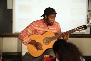 Henry performs for the students while they draw their art work.
